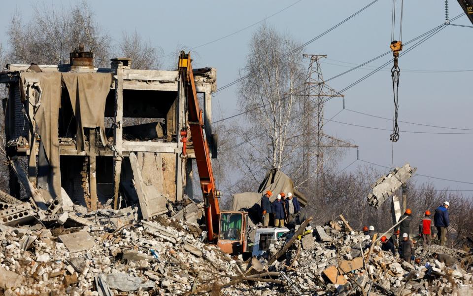 Workers remove debris of a destroyed building purported to be a vocational college used as temporary accommodation for Russian soldiers, 63 of whom were killed in a Ukrainian missile strike as stated the previous day by Russia's Defence Ministry, in the course of Russia-Ukraine conflict in Makiivka (Makeyevka), Russian-controlled Ukraine, January 3, 2023. REUTERS/Alexander Ermochenko - REUTERS/Alexander Ermochenko