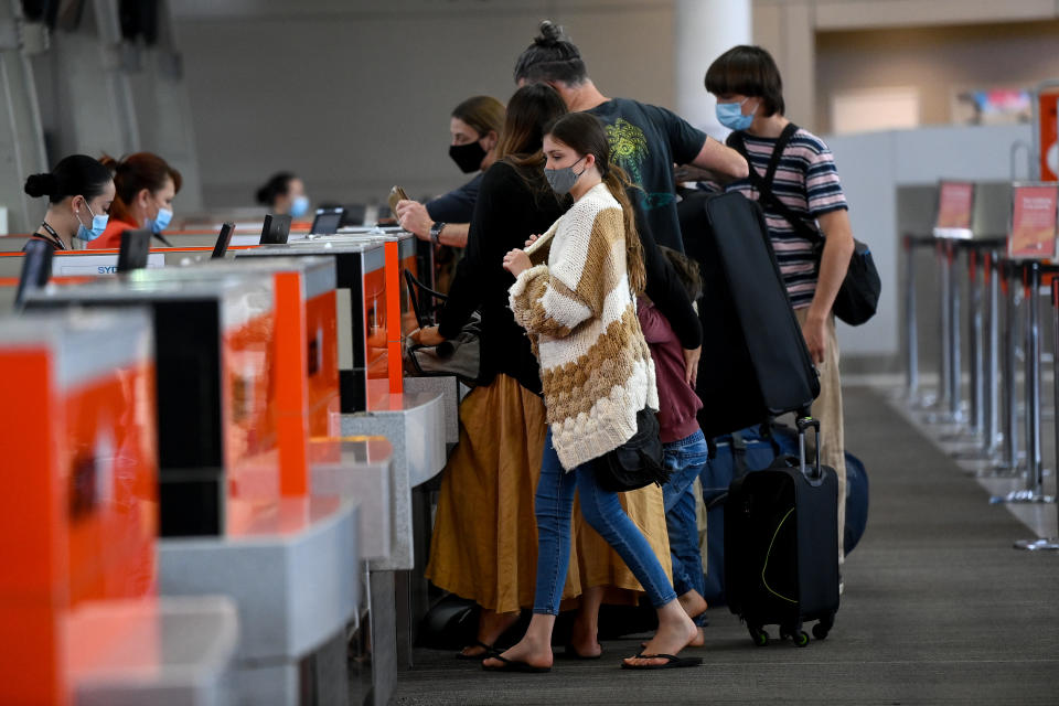 Passengers wear face masks as they line up at the Jetstar check in terminal at Sydney Domestic Airport in Sydney, Friday, November 5, 2021. 