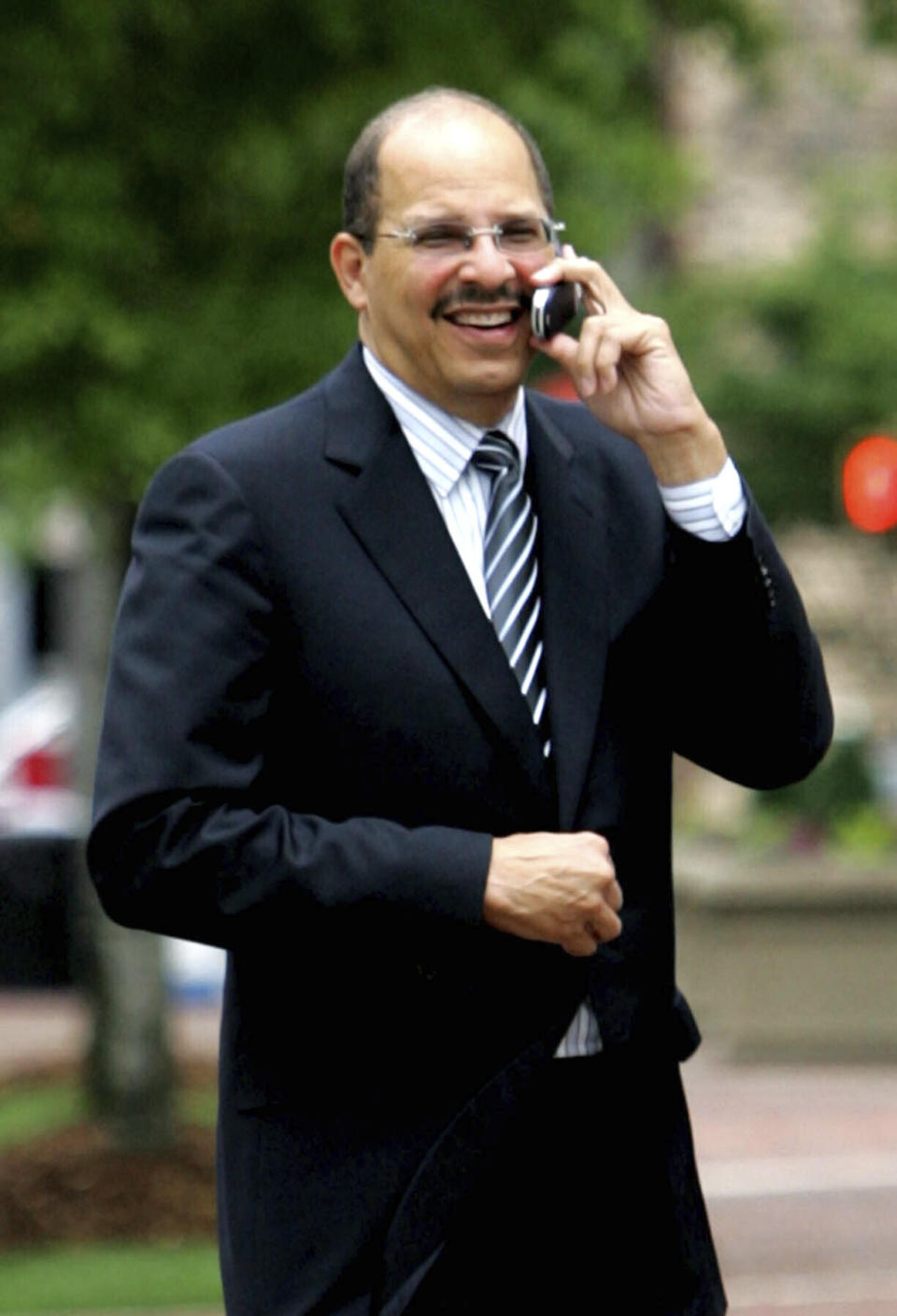 FILE - In this June 1, 2005, file photo, Defense attorney Donald Watkins talks on his phone outside the Hugo Black Federal Courthouse in Birmingham, Ala., during deliberations in the fraud trial of HealthSouth Corp. founder and fired CEO Richard Scrushy. Watkins, convicted of swindling NBA star Charles Barkley and using the name of former Secretary of State Condoleezza Rice to bolster an investment scam, was sentenced to five years in prison Tuesday, July 16, 2019. He and his son, Donald Watkins Jr., were convicted on fraud and conspiracy charges earlier this year. The two men stole more than $15 million from investors and a bank, prosecutors said. (AP Photo/Butch Dill, File)