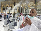 A Muslim pilgrim prays beside robots used to vacuum and sanitize air at the Grand Mosque in the Saudi Arabia's holy city of Mecca, Tuesday, July 5, 2022. Saudi Arabia is expected to receive one million Muslims to attend Hajj pilgrimage, which will begin on July 7, after two years of limiting the numbers because of coronavirus pandemic. (AP Photo/Amr Nabil)