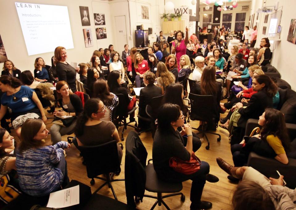 This April 16, 2013 photo provided by Wix Lounge shows group facilitator Franne McNeal, right, standing, and organizer Mary Dove, standing left, addressing women at a "Lean In" meeting in New York. The group is inspired by Facebook COO Sheryl Sandberg's book "Lean In" which seeks to empower women in the workplace. (AP Photo/Wix Lounge, Galo Delgado)