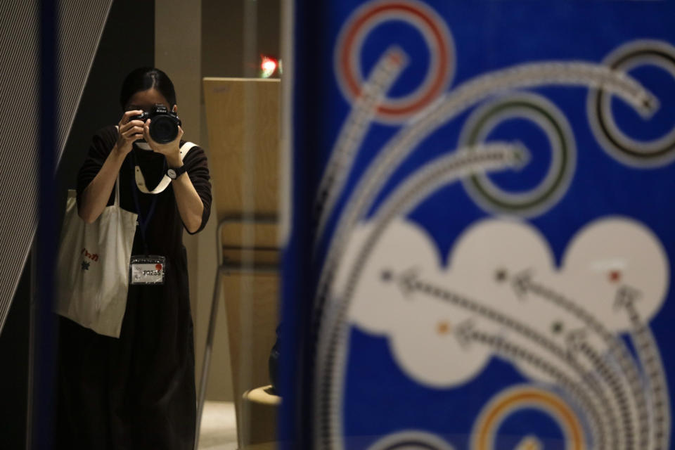 A photographer takes pictures of official posters selected for the Tokyo Olympics and Paralympics, at the Museum of Contemporary Art Tokyo Monday, Jan. 6, 2020. The official posters are out for this year's Tokyo Olympics and Paralympics. The 20 posters have been created by 19 artists in fields ranging from painting, graphic design, and photography. Calligraphy and Japanese manga are also represented. (AP Photo/Jae C. Hong)