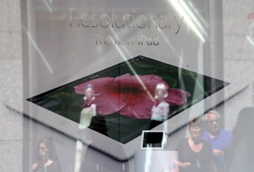Pedestrians walk past an Apple store advertising the iPad. Apple has paid $60 million to end a dispute over who could use the iPad name in China, a court said Monday, giving the US tech giant more certainty in selling its tablet computer in the Chinese market