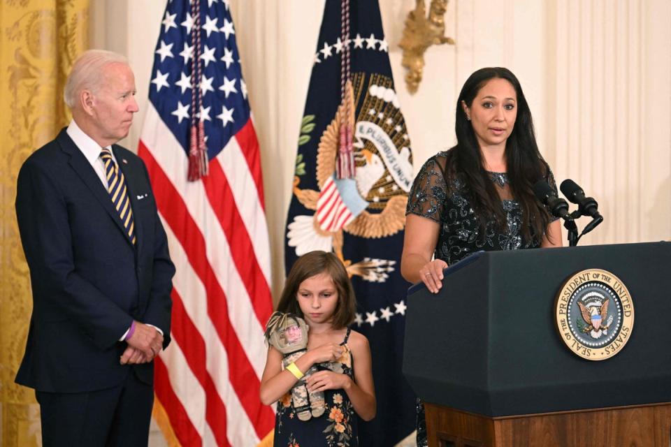 President Joe Biden looks on as Danielle Robinson, wife of Sgt First Class Heath Robinson, speaks during a signing ceremony for the PACT Act of 2022 (AFP via Getty Images)