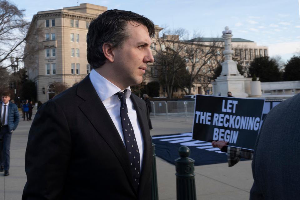 Jason Murray, lead attorney for the Colorado voters, walks past anti-Trump demonstrators outside the U.S. Supreme Court on Thursday as the court consideres whether former President Donald Trump is eligible to run for president.