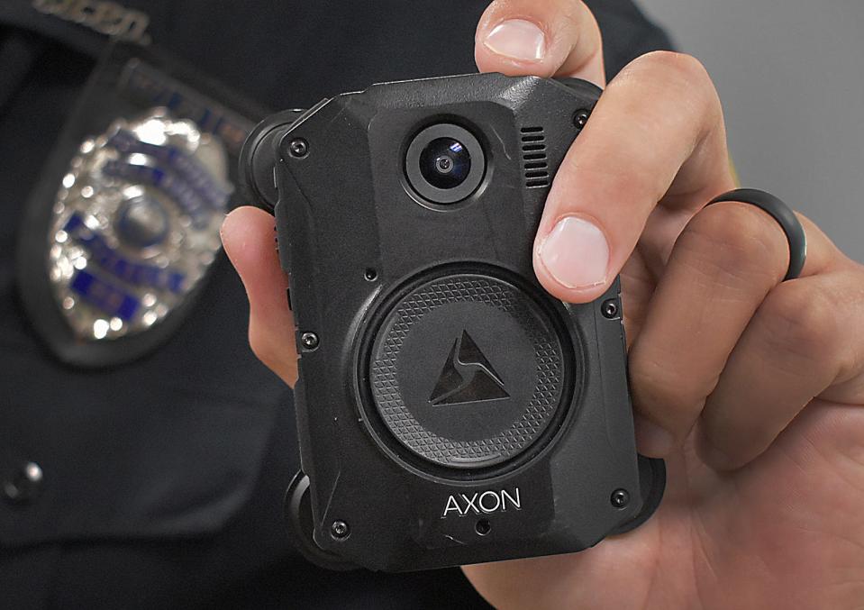 A Fall River police officer holds a body-worn camera in 2022.