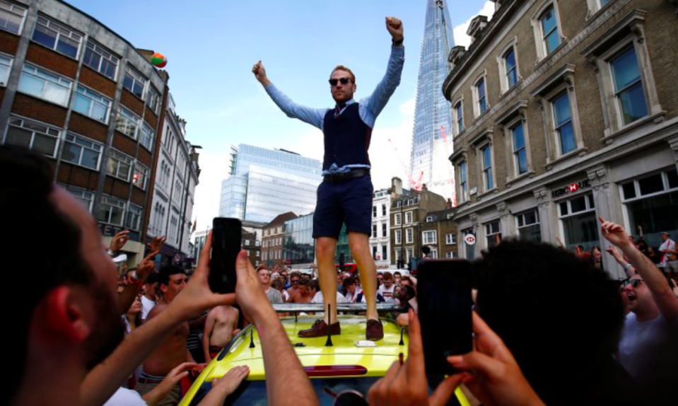 <em>A man dressed in a Gareth Southgate waistcoat celebrated on the roof of the vehicle (Reuters)</em>