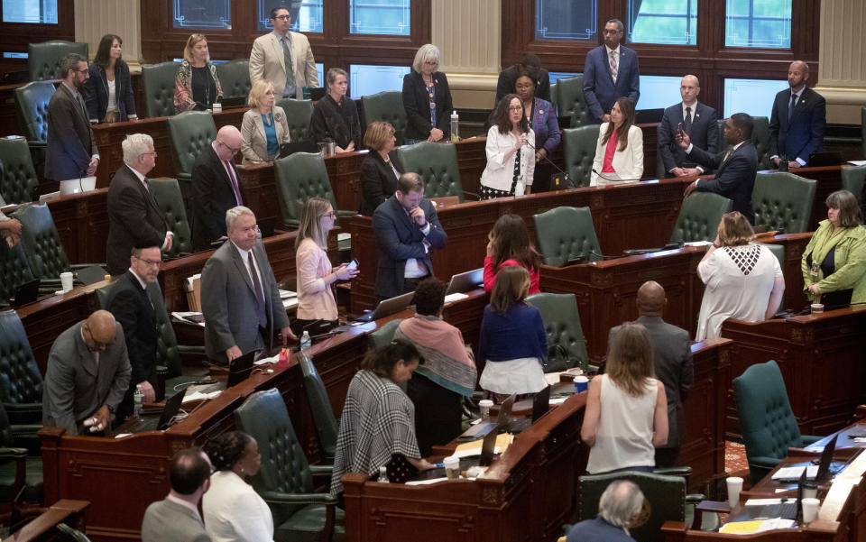 As her Democrat colleagues stand at their desks, Illinois state Rep. Kelly Cassidy, D-Chicago, makes a final plea for the Reproductive Health Act on the floor of the Illinois House chambers Tuesday, May 28, 2019, in Springfield, Ill. The House voted 64-50 on Rep. Cassidy's Reproductive Health Act, which would rescind prohibitions on some late-term abortions and restraints such as criminal penalties for doctors performing abortions. (Ted Schurter/The State Journal-Register via AP)