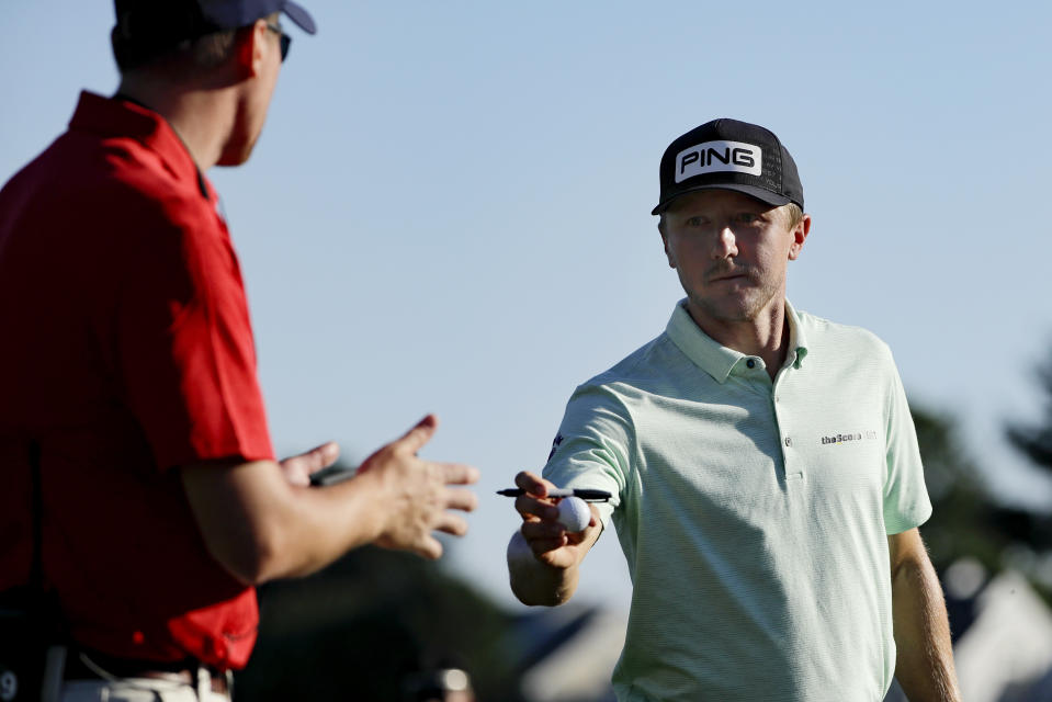 Mackenzie Hughes, right, of Canada, gives a signed ball to a volunteer after finishing the second round of the Travelers Championship golf tournament at TPC River Highlands, Friday, June 26, 2020, in Cromwell, Conn. (AP Photo/Frank Franklin II)