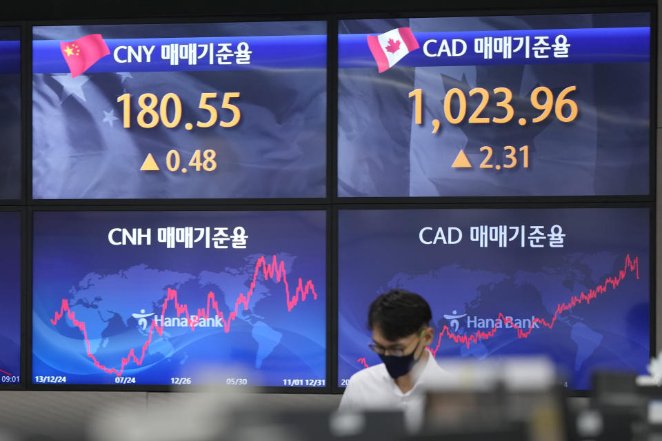 A currency trader walks near the screens showing the foreign exchange rates at a foreign exchange dealing room in Seoul, South Korea, Tuesday, Oct. 11, 2022. Asian shares were mostly lower on Tuesday as losses in technology-related shares weighed on global benchmarks.(AP Photo/Lee Jin-man)