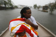 <p>Demetres Fair holds a towel over his daughter Damouri Fair, 2, as they are rescued by boat by members of the Louisiana Department of Wildlife and Fisheries and the Houston Fire Department during flooding from Tropical Storm Harvey in Houston, Monday, Aug. 28, 2017. (Photo: Gerald Herbert/AP) </p>