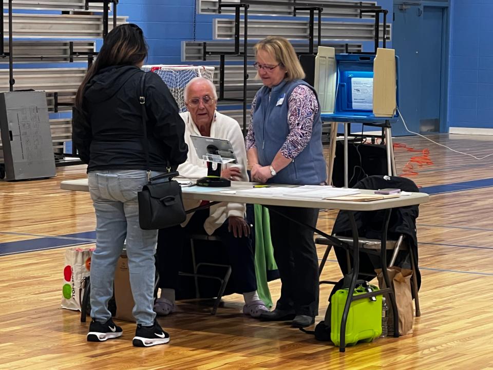 Evelin Reyes of Middletown checks in at Gaudet Middle School to vote for the first time.