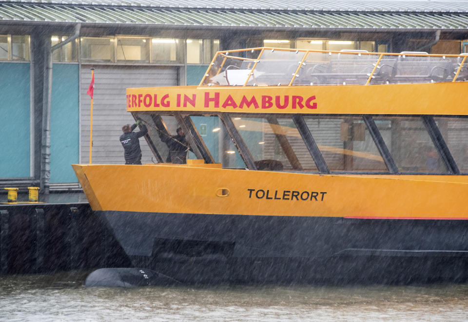 People repair the windows of the harbor ferry Tollerort after it broke during the storm in Hamburg, Germany, Thursday, Feb. 17, 2022. A large wave broke the front windows of the Hamburg harbor ferry during the storm and one passenger was reported to be slightly injured. (Daniel Bockwoldt/dpa via AP)