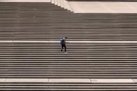 A lone man stands on the steps of the Sydney Opera House in Sydney