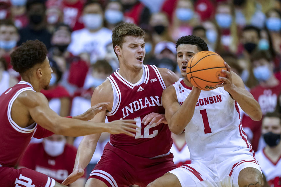 Wisconsin's Johnny Davis (1) looks to pass the ball as Indiana's Miller Kopp (12) defends during the first half of an NCAA college basketball game Wednesday, Dec. 8, 2021, in Madison, Wis. (AP Photo/Andy Manis)