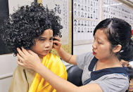 詠琪為扮演釋迦牟尼的四歲小朋友整理假髮。