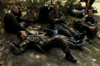 Town hall clerk Monika Pawlik, 24, and other territorial soldiers take a break during their training for Poland's Territorial Defence Forces, near a shooting range near Siedlce, Poland, April 21, 2018. REUTERS/Kacper Pempel/Files