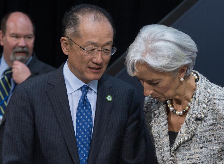 World Bank President Jim Yong Kim speaks with International Monetary Fund (IMF) Director General Christine Lagarde, at the IMF/WB Spring Meetings in Washington, DC, on April 17, 2015