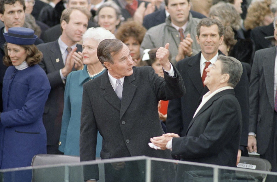 President-elect George Bush gives President Ronald Reagan a thumbs up as Reagan reacts prior to Bush being sworn in as the 41st president of the United States outside the Capitol, Jan. 20, 1989, in Washington. Behind Reagan is Bush's son George W. Bush. (AP Photo/Ron Edmonds)