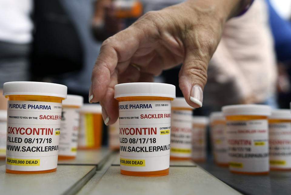 FILE - In this Aug. 17, 2018 file photo, family and friends who have lost loved ones to OxyContin and opioid overdoses leave protest messages written on pill bottles outside the headquarters of Purdue Pharma, which is owned by the Sackler family, in Stamford, Conn. On Monday, April 29, 2019, nearly 30 West Virginia hospitals and 10 affiliates in Kentucky banded together to sue some of the country’s largest opioid companies, saying they flooded Appalachia with powerful painkillers and forced medical centers to deal with the financial repercussions. (AP Photo/Jessica Hill, File)