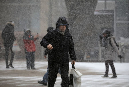 People walk during a snow storm in Canary Wharf in London, Britain February 27, 2018 REUTERS/Kevin Coombs