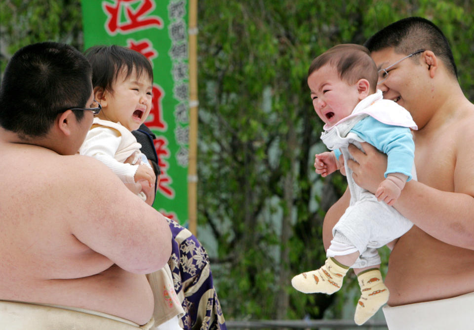 Babies Nozomi Ito, left, and Shinichiro Ishikura, right, are held by college sumo wrestlers as they compete in a traditional baby screaming contest, known as Naki Sumo, at the Senso-ji temple in Tokyo, in April 29, 2006 file photo. / Credit: KOJI SASAHARA/AP