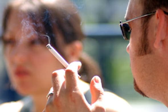 A4CKBW Royalty free photograph of British college university student smoking outside due to smoking ban in London UK alamy secon