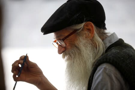 Michael Netzer, an American comics artist formerly named Mike Nasser, sketches a passerby on a bench in Jerusalem