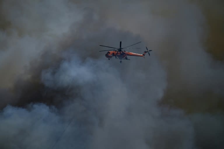 Un helicóptero sobrevuela un incendio en Keratea, cerca de Atenas, el 30 de junio de 2024 (Aris Messinis)