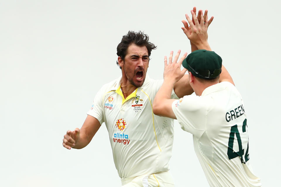 Mitchell Starc (pictured left) high-fives his teammate after dismissing Rory Burns on day one of the First Test Match.