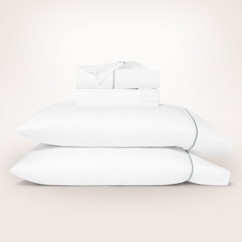 Boll & Branch Embroidered Sheet set on top of pillows