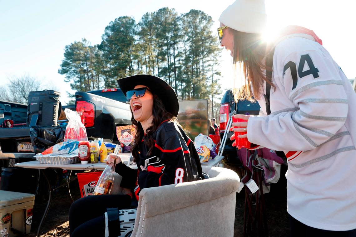 Nicole Willis, left, laughs with Abby D’Lugin while tailgating before the NHL Stadium Series game between the Carolina Hurricanes and the Washington Capitals at Carter-Finley Stadium in Raleigh, N.C., Saturday, Feb. 18, 2023. Willis is recovering from hip surgery she had 10 days ago so her friends brought a chair to make sure she could tailgate and enjoy the game.