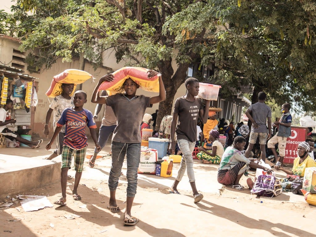 Young boys carry sacks of food after being displaced by violence in northern Mozambique (John Wessels/AFP via Getty Images)