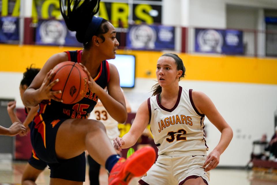 Purcell Marian Cavaliers forward Seini Hicks (15), left, gains possession of the ball after a rebound during the high school girls basketball game between the Cooper Jaguars and Purcell Marian Cavaliers on Tuesday, Dec. 12, 2023, at Randall K. Cooper High School in Union, Ky. Purcell Marian won 56-51.