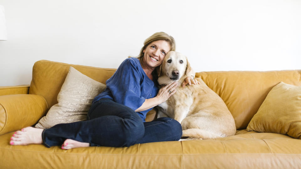 Woman sharing sofa with her golden retriever