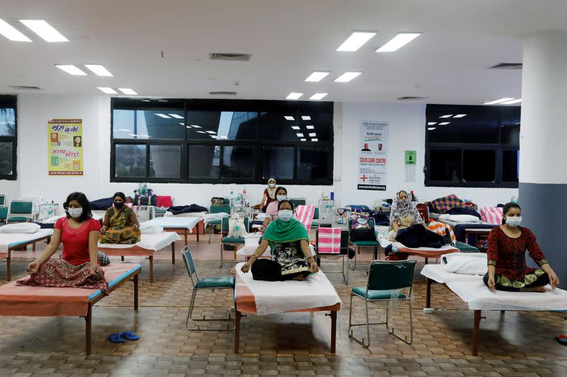 People suffering from the coronavirus disease (COVID-19) perform yoga inside a care centre for COVID-19 patients at an indoor sports complex in New Delhi