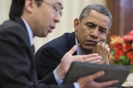 U.S. President Barack Obama watches as Todd Park (L), Assistant to the President and Chief Technology Officer, shows him information on a tablet during a meeting in the Oval Office, in this April 15, 2013 handout photograph obtained on October 24, 2013. REUTERS/Pete Souza/The White House/Handout