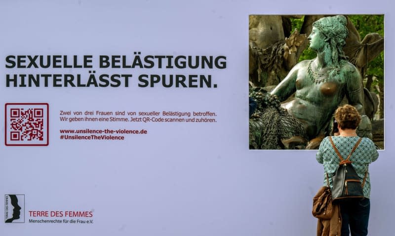 A poster erected by the Terre de Femmes organization with the inscription "Sexual harassment leaves its mark" stands in front of the female figure with a fishing net and grapes (also known as Ms. Rhine) at the Neptune Fountain. The women's rights organization sets an example against sexual harassment at well-known female bronze statues in Munich, Berlin and Bremen. Monika Skolimowska/dpa