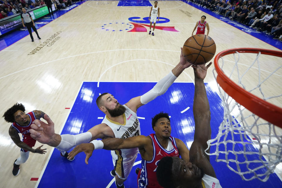 Philadelphia 76ers' Kyle Lowry, center, struggle for a rebound between New Orleans Pelicans' Jonas Valanciunas, left, and Zion Williamson during the first half of an NBA basketball game, Friday, March 8, 2024, in Philadelphia. (AP Photo/Matt Slocum)