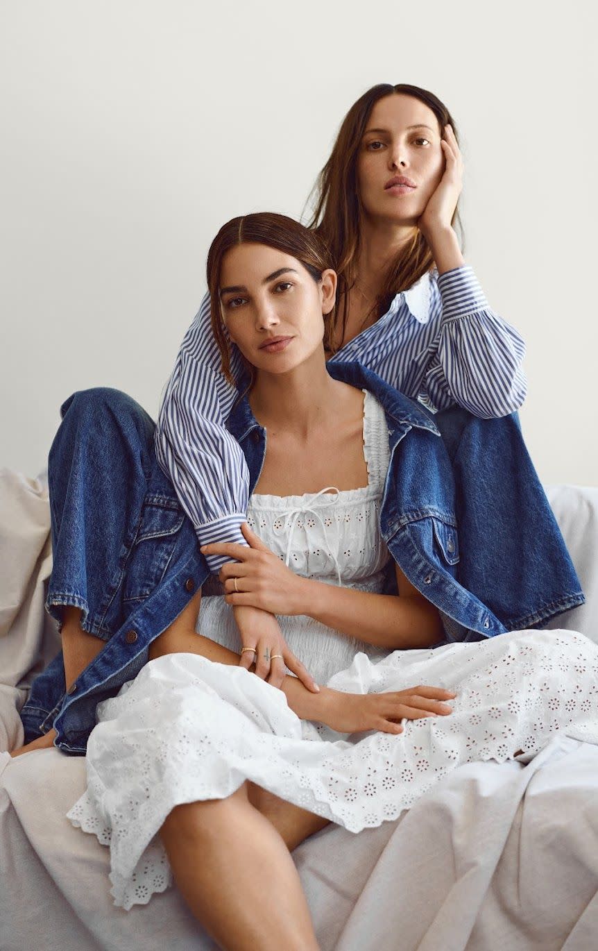 two women sitting on a bed