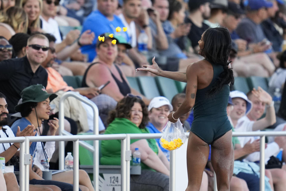 Tara Davis-Woodhall, celebrates by throwing rubber ducks to the crowd after winning the women's long jump during the U.S. track and field championships in Eugene, Ore., Sunday, July 9, 2023. (AP Photo/Ashley Landis)