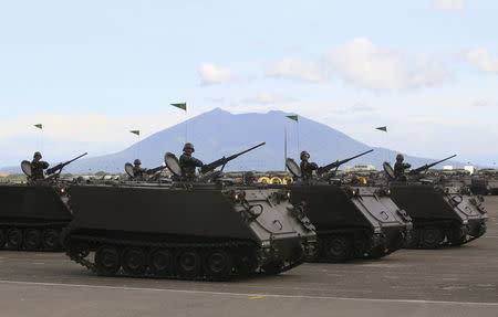 A column of tracked armoured vehicles roll ahead in a parade during the 80th founding anniversary of the Armed Forces of the Philippines held inside Clark Air Base, formerly a U.S. base, in Angeles city, Pampanga province, north of Manila December 21, 2015. REUTERS/Romeo Ranoco