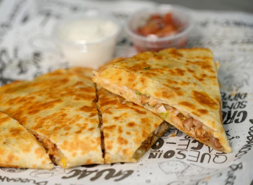 A "Burritodilla" is served with sour cream and salsa at Bubbakoo's Burritos. The Burritodilla combines burrito ingredients served in the style of a grilled quesadilla.