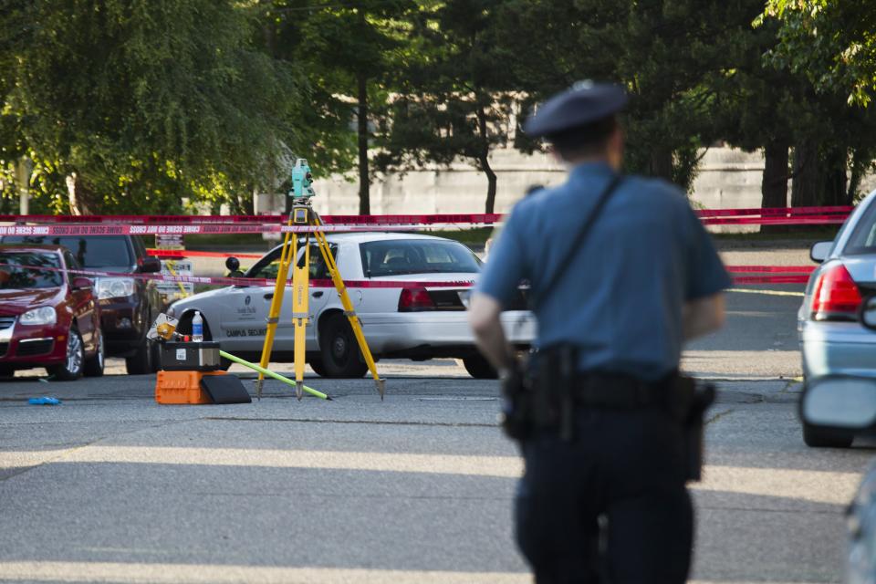 Police investigate the scene of a shooting on campus at Seattle Pacific University in Washington June 5, 2014. A man armed with a shotgun opened fire on Thursday at the small Christian college in Seattle, killing one person and wounding three others before he was subdued by a group of students and arrested, Seattle police and hospital officials said. (REUTERS/David Ryder)