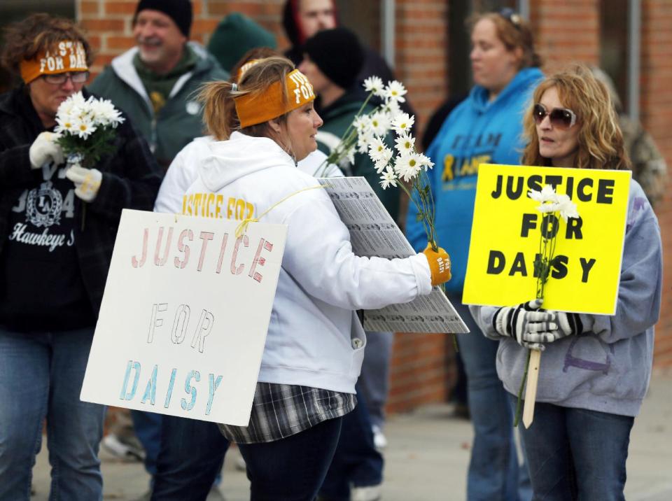 FILE - In this Oct. 22, 2013, file photo supporters pass out flowers in Maryville, Mo., before a rally for Daisy Coleman, a girl who says she was sexually assaulted when she was 14. Matt Barnett, accused of sexually assaulting Coleman when he was 17, was charged Thursday, Jan. 9, 2014, with a misdemeanor child endangerment charge. (AP Photo/Orlin Wagner, File)