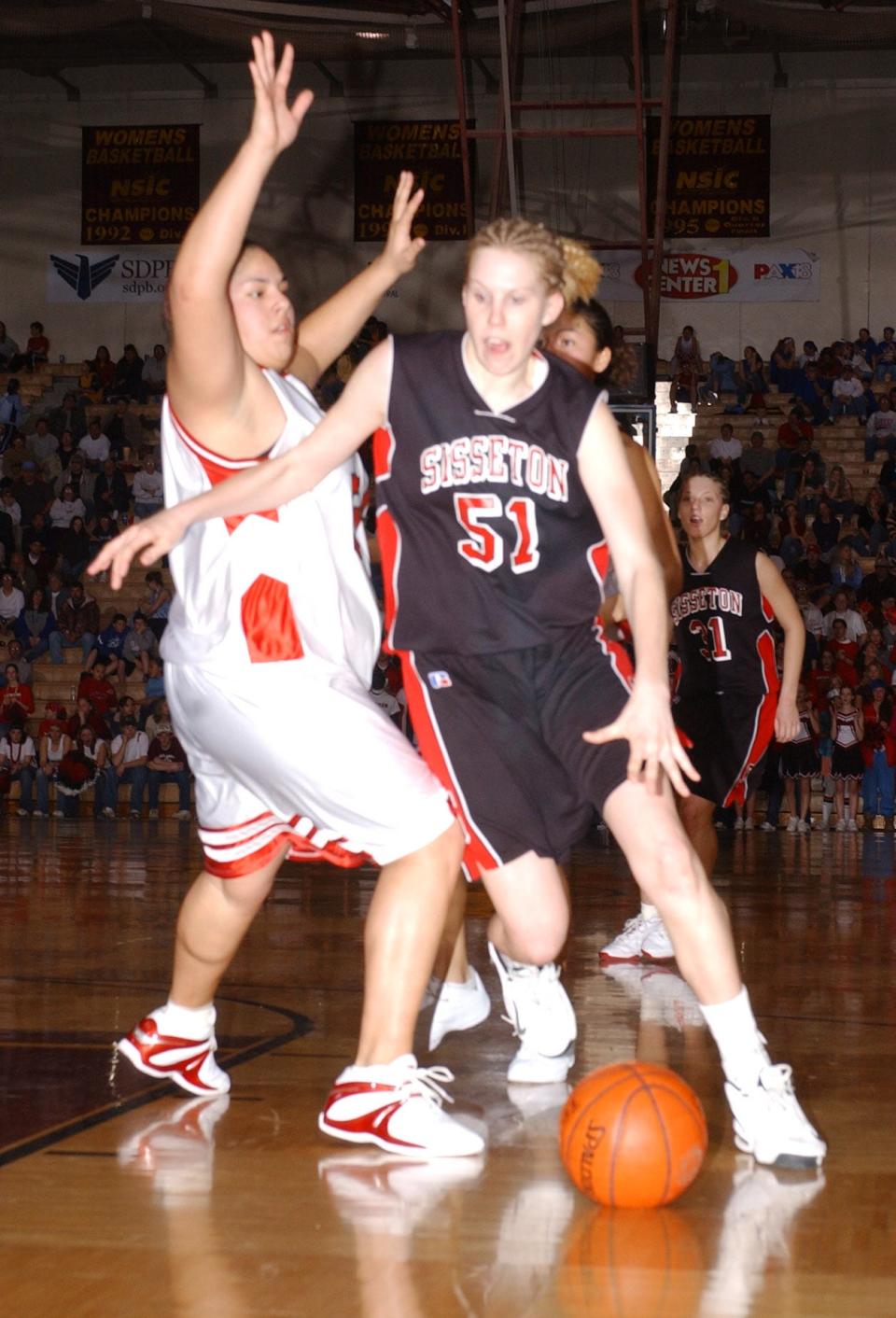 Sisseton's Courtney Grimsrud (51) drives past a Pine Ridge player during the championship game of the 2004 state Class A girls basketball tournament in the Barnett Center at Aberdeen. Sisseton won 68-57.