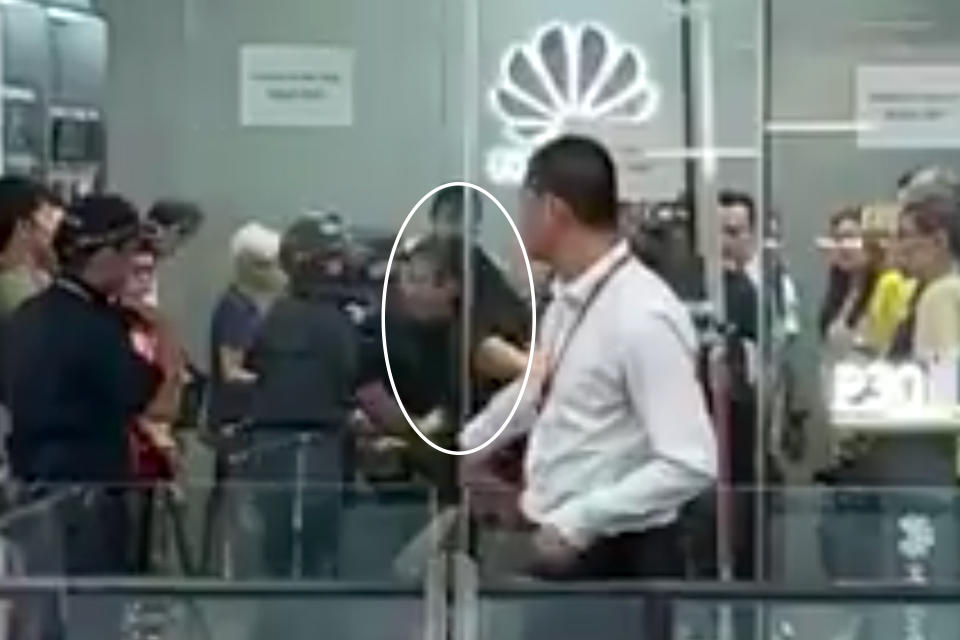 Ng Puay Chin seen being arrested at the Huawei shop on 26 July. (PHOTO: YouTube screengrab)