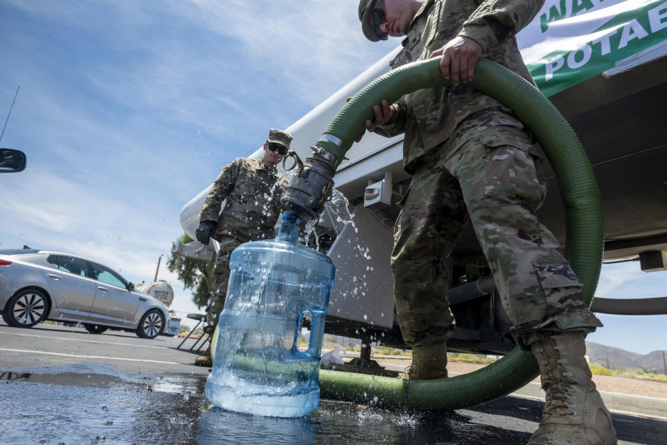 Private First Class Evan Siebuhr, left, and Private First Class Henry Marquez of the 670th Military Police fill water bottles for residents in Trona, Calif., on Tuesday July 9, 2019. Two strong quakes — a magnitude 6.4 and a 7.1, respectively — struck Thursday and Friday that were felt across a large swath of southern California. It could be several more days before water service is restored to the tiny town of Trona, where officials trucked in portable toilets and showers. (James Quigg/The Daily Press via AP)