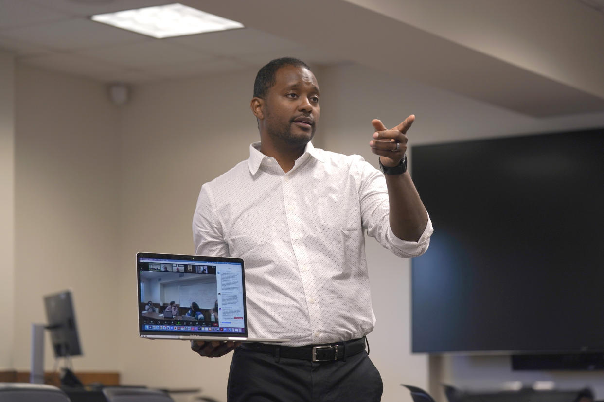 Texas Christian University assistant professor of literature Brandon Manning holds a computer as he leads a seminar class at TCU campus in Fort Worth, Texas, Tuesday, Feb. 15, 2022. Manning was born in the U.S. South and had been itching to return there, but Manning didn't want to go back to his native Atlanta because of the traffic, cost of housing and sprawl. He made a list of smaller cities in the South he would consider, and when the opportunity came for Manning to take a job teaching in Texas at TCU he jumped. (AP Photo/LM Otero)