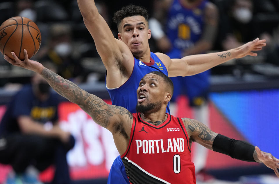 Portland Trail Blazers guard Damian Lillard (0) shoots next to Denver Nuggets forward Michael Porter Jr. (1) during the second half of Game 1 of a first-round NBA basketball playoff series Saturday, May 22, 2021, in Denver. (AP Photo/Jack Dempsey)